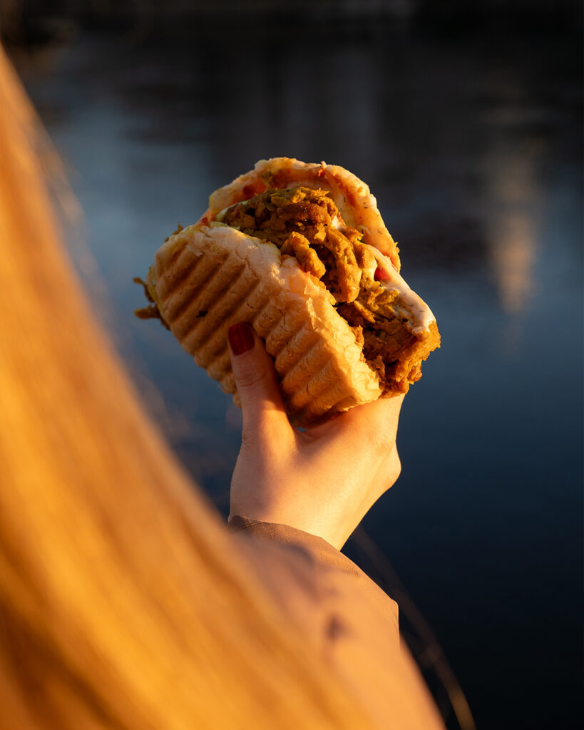 Frau hält Döner am Donauufer in Regensburg